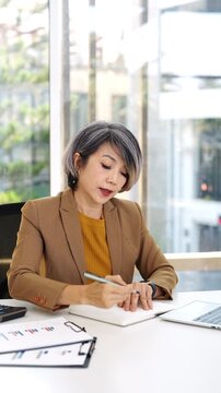 Business woman working in office checking documents.Accounting manager executive  reading paper file financial report, tax invoice.