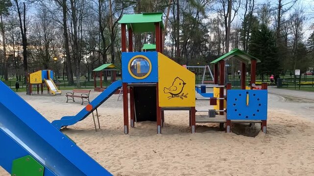 NOWY TARG, POLAND - APRIL 23, 2026: A charming playground with modern equipment on a sand surface.