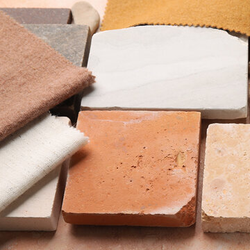Natural material swatches flat lay with stone tiles and linen fabric