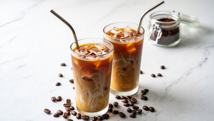 Two tall glasses filled with iced coffee and milk, featuring intricate cream swirls and reusable