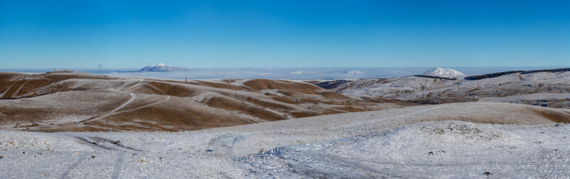 View of mountain peaks in Caucasus in sunny winter day against blue sky