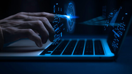 Close up of a persons hand on a laptop keyboard with blue glowing screen and futuristic interface in the dark  technology and innovation concept © OnlineVector
