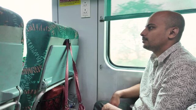 Man gazes out window on Kalka Shimla Toy Train, Himachal Pradesh, India
