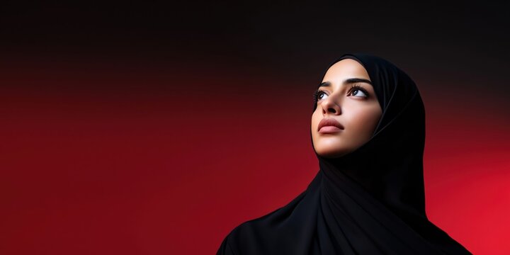 Elegant Emirati woman in black abaya and hijab gazes upwards with thoughtful expression