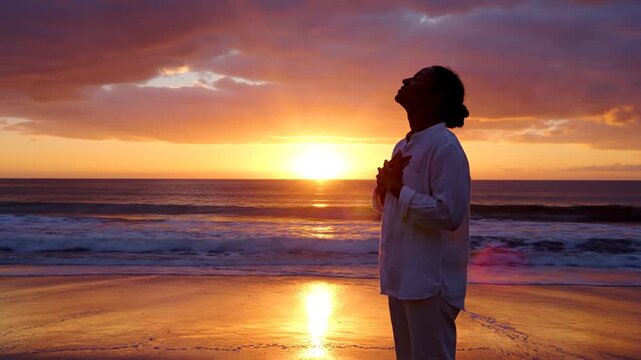 Person silhouetted on beach at beautiful ocean sunset