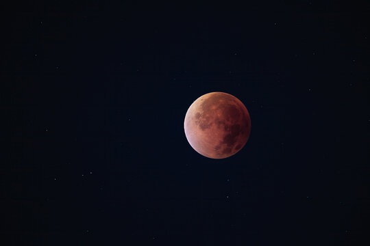 Stunning total lunar eclipse with a red blood moon in a starry sky
