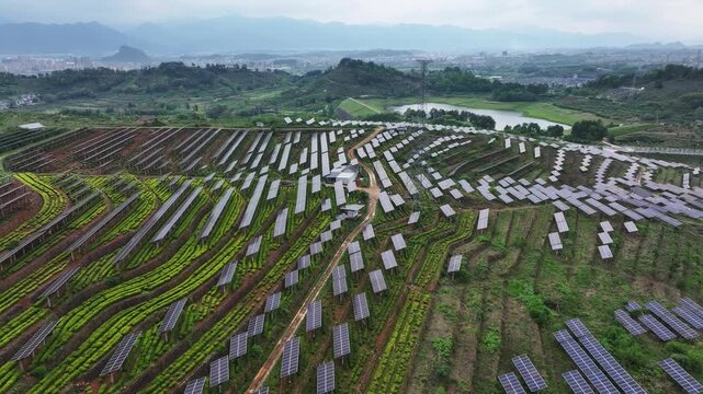 Terraced photovoltaic power station interwoven with green farmland in rural hilly landscape