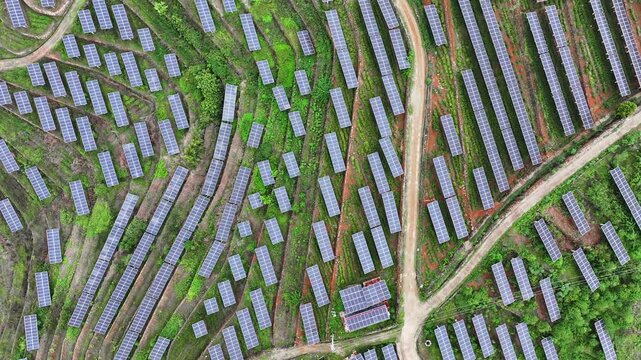Aerial view of a photovoltaic power station arranged in terraced hillside formations