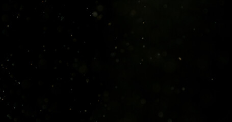 Obraz premium Close-up of floating dust particles in air, isolated on black background. Minimalist abstract texture with soft light, designed as VFX overlay for compositing.