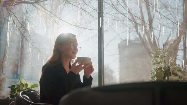 Silhouetted woman enjoying sunrise coffee, city skyline blurred through frosted window, warm rimlight outlines profile, plants on table, quiet meditative ritual of early commuter preparing for day