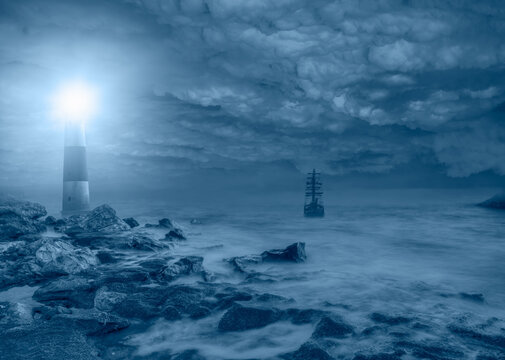 Beautiful night seascape with lighthouse An old ship dangerously approaching the rocks in stormy weather at blue dark night