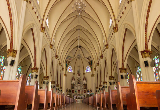 Main aisle inside the church of Yaguara with beautiful decorations for the celebration of the Holy Eucharist with parishioners in Huila, Colombia. Concept of catholic religion and interior