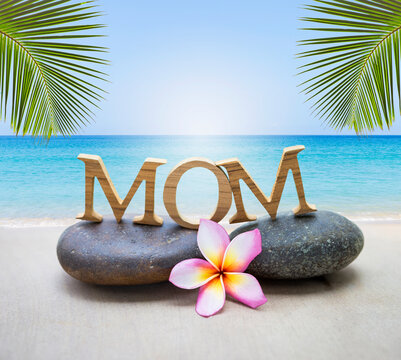 Mother's day card background idea, mom wooden font on stone over tropical beach background