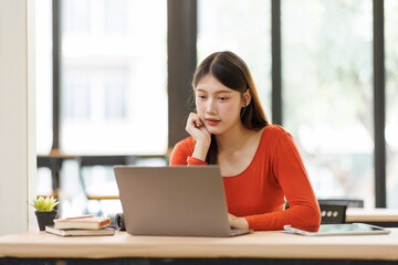 Obraz premium Asian woman concentrating on laptop for remote work or studying