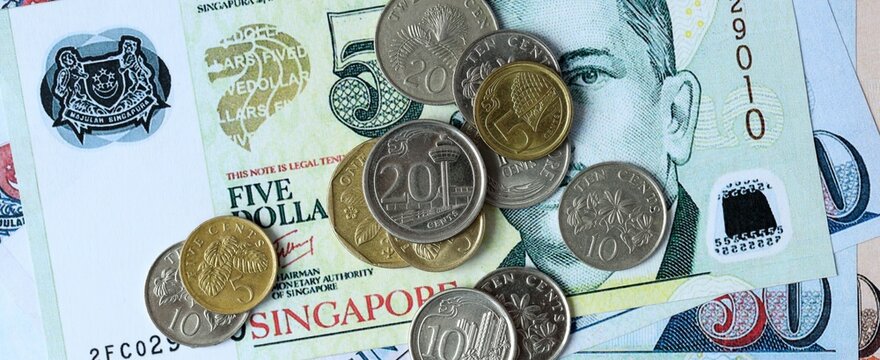 Singapore dollar money bills and coins on table. Singapore cash of SGD currency close up