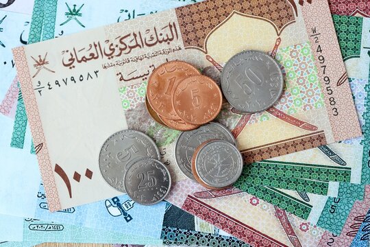 Omani rial money bills and coins on table. Oman cash of OMR currency close up