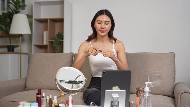 Asian beauty influencer recording makeup tutorial at home with smartphone, skincare and cosmetics content creator livestream.