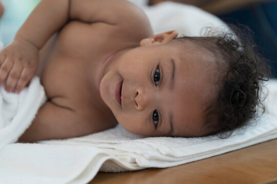 African American father and cute baby toddler. Father cleaning and health newborn child, wearing newborn baby diaper after taking shower