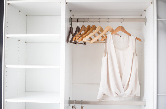White shirts hanging neatly in closet, organized storage
