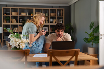 Fototapeta premium Young couple enjoying work and leisure at home