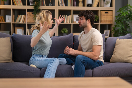 Couple having conflict, woman shouting at worried man