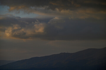Obraz premium Dramatic storm clouds over mountain ridge at dusk
