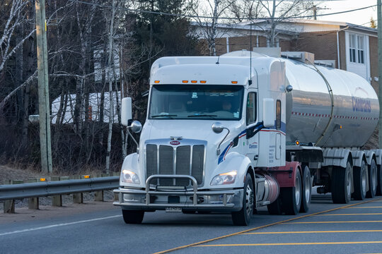 Quebec, Canada, 24 April 2026 : A white Peterbilt semi-truck with a Contrans tanker trailer drives on a road.