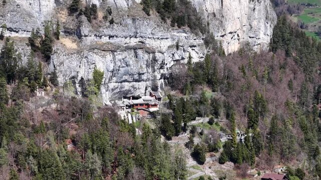 Aerial View of Saint Beatus Caves Entrance with Waterfall and Historic Buildings, Lake Thun, Switzerland