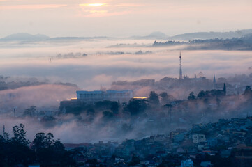 Fototapeta premium The view of Da Lat from Du Sinh Cemetery towards the city center. Da Lat on a morning shrouded in mist and early sunlight, a magical morning light. Beautiful Vietnamese scenery.