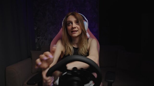 Caucasian Woman Smiling During Racing Stream With Headset, Celebratory Expression, Hands On Wheel, Studio