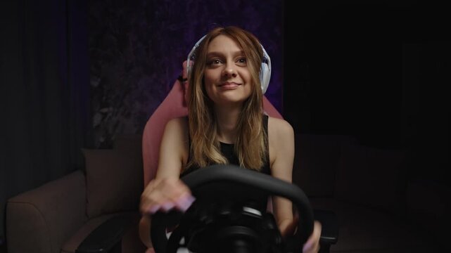 Woman gamer reacting with surprise and relief at wheel, headset on in pink chair, hands expressive, shifting from tense focus