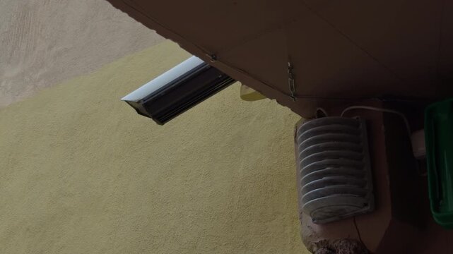 Outline of pipe against textured wall. Shadowed pipe outline contrasted with textured and shadowed wall. Profile of vent pipe set against wall with intricate textures and shadow effects