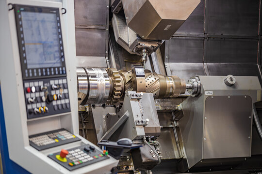CNC milling machine machining large metal gear component in factory.