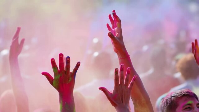 Colorful hands raised in celebration at a vibrant festival. A joyful expression of unity and community spirit during a cultural event