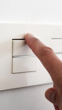 Close-up of finger switching a light off at home