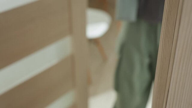 Metal door handle on wood door, closeup showing lever and lock on contemporary interior panel, subtle light and shadow, quiet invitation and everyday threshold moment, hint of person entering