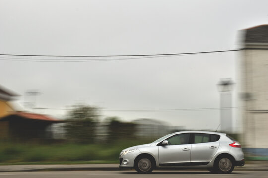 Un coche plateado avanza r&aacute;pidamente por una carretera rural.