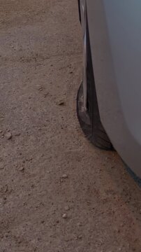 Dirt road scene with sinking tire tread marks. Automotive depiction of tire on rugged offroad trail. Suspended tire on dusty path illustrating resilience and adventure in slow motion