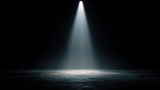 Spotlight illuminates a dark stage floor with dramatic light rays and atmospheric haze
