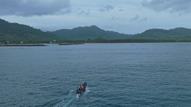 Indonesian fishing boat sailing towards red island java