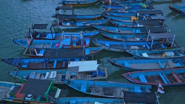 Traditional blue fishing boats moored at red island java harbor