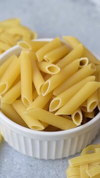 Italian uncooked dry penne regate pasta ready for cooking. Dry penne pasta as a food background for your design.