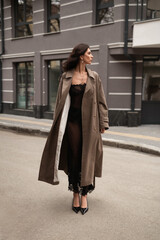 Obraz premium Beautiful and stylish young woman crossing road at pedestrian in city. Fashion street style.
