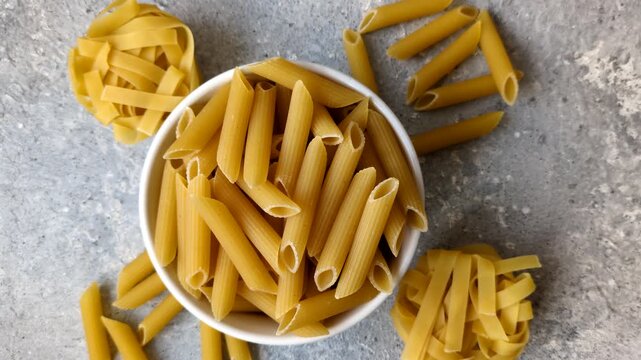 Italian uncooked dry penne regate pasta ready for cooking. Dry penne pasta as a food background for your design.