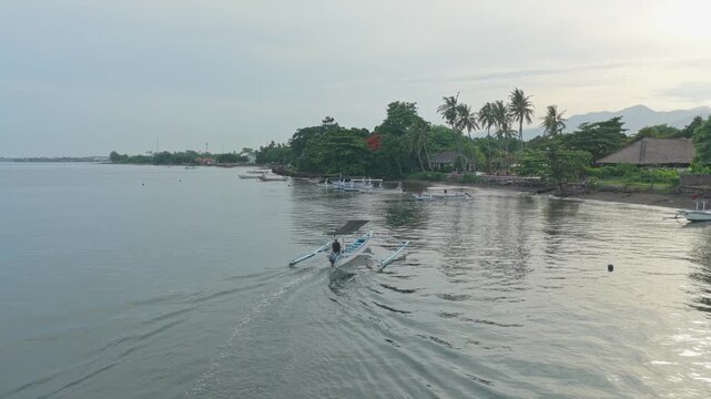 Traditional balinese jukung boat sailing in lovina beach
