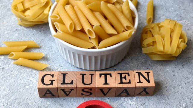 Italian uncooked dry penne regatta pasta with a gluten prohibition sign. The gluten prohibition sign as a background for your design.