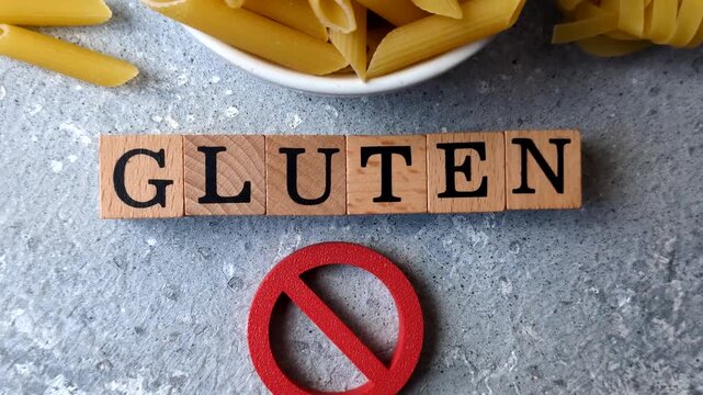 Italian uncooked dry penne regatta pasta with a gluten prohibition sign. The gluten prohibition sign as a background for your design.