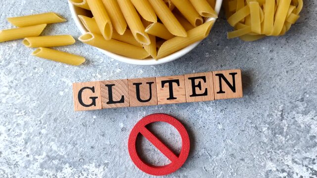 Italian uncooked dry penne regatta pasta with a gluten prohibition sign. The gluten prohibition sign as a background for your design.
