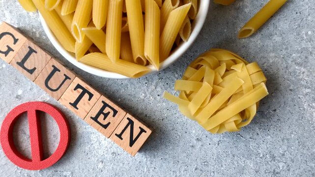 Italian uncooked dry penne regatta pasta with a gluten prohibition sign. The gluten prohibition sign as a background for your design.