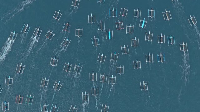Aerial top down view of traditional balinese boats sailing in the ocean